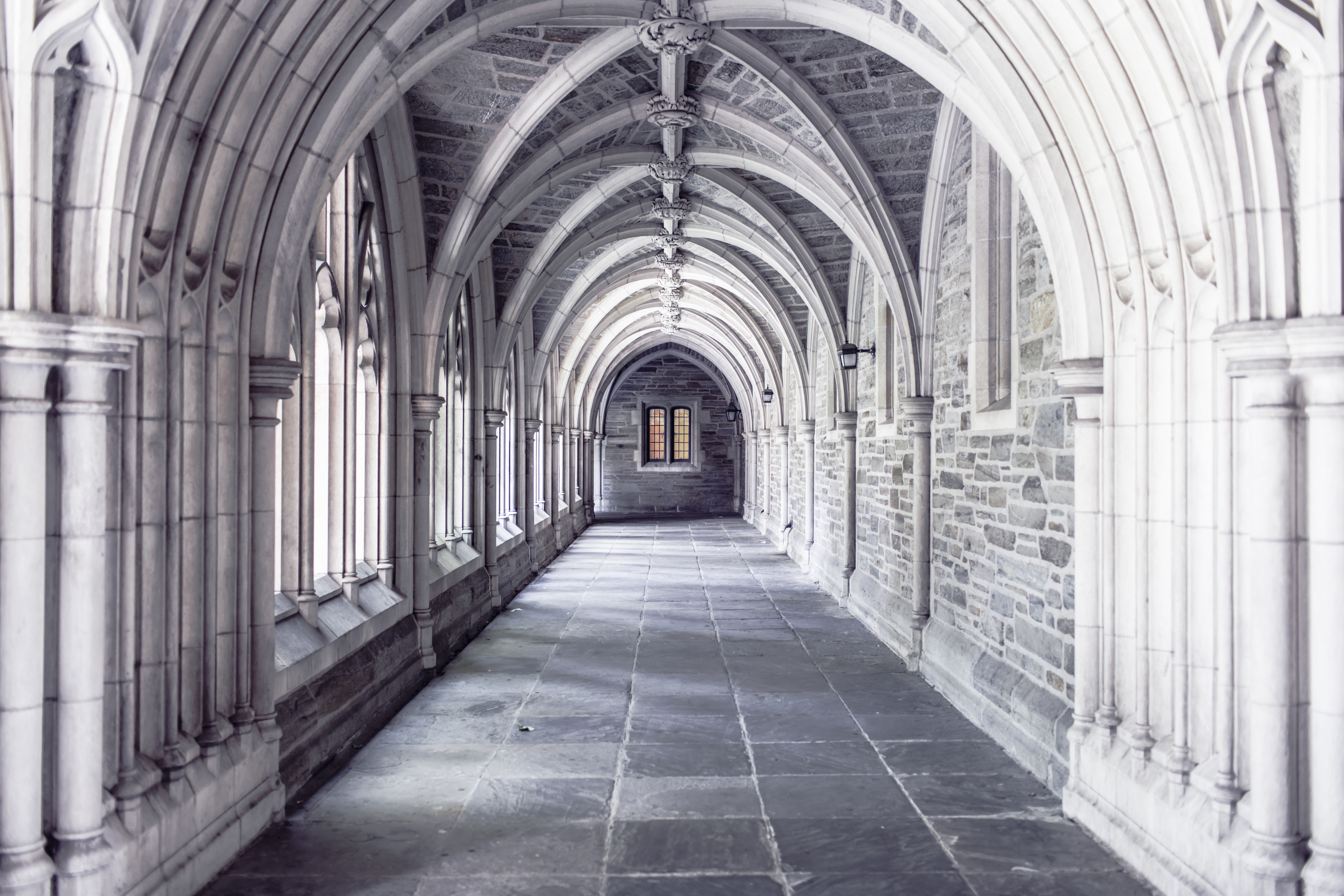A photograph of a church hallway with arches.