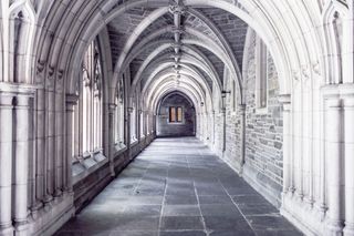 A photograph of a church hallway with arches.
