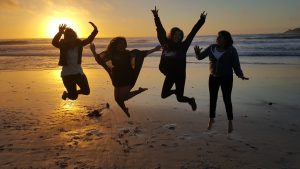 Sunset on the beach with jumping silhouettes.