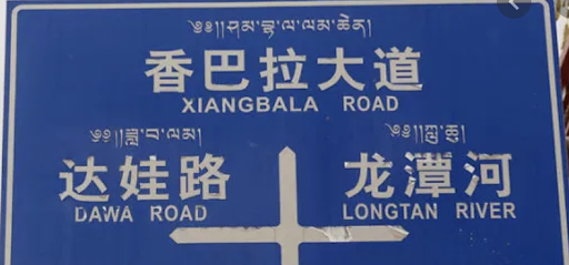 A street sign in Tibet showing how small the Tibetan language is.