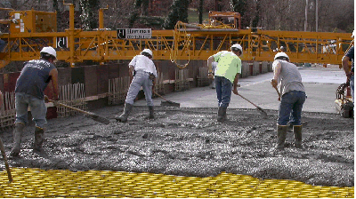 image of men working to spread cement on a bridge