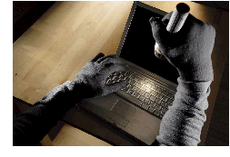 image of a thief shining a flashlight on a laptop