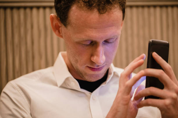 A photograph of a blind man using a smartphone touchscreen.