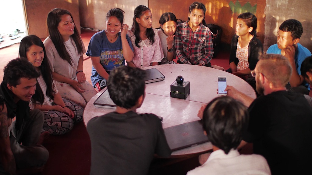 A photograph of adolescents in Kathmandu, Nepal talking around a table