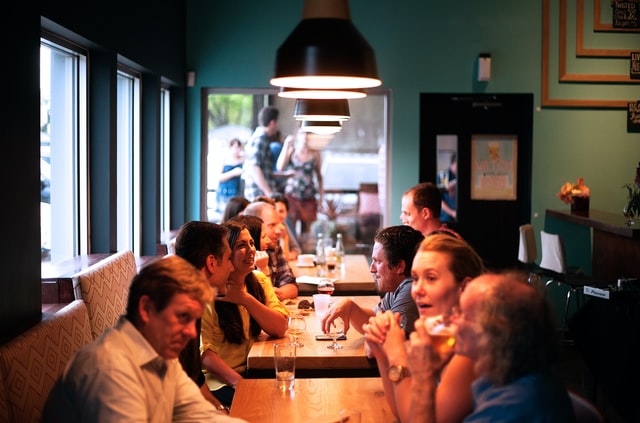 A photograph of people talking at a restaurant