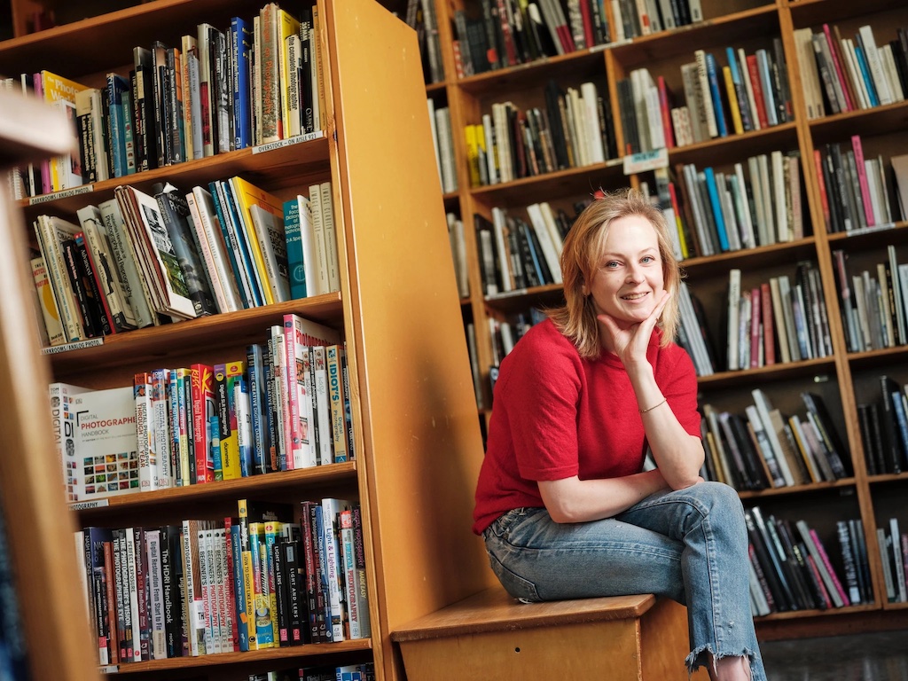 A photo of Emily Powell in front of book shelves.