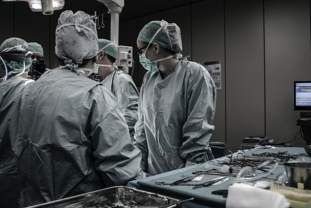 A photograph of surgeons deliberating by an operating table.