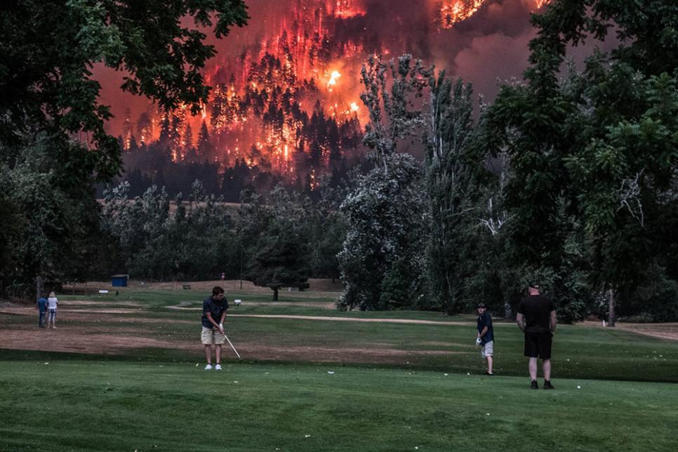 A photograph of Oregon wildfires in the background, golfers in the foreground.