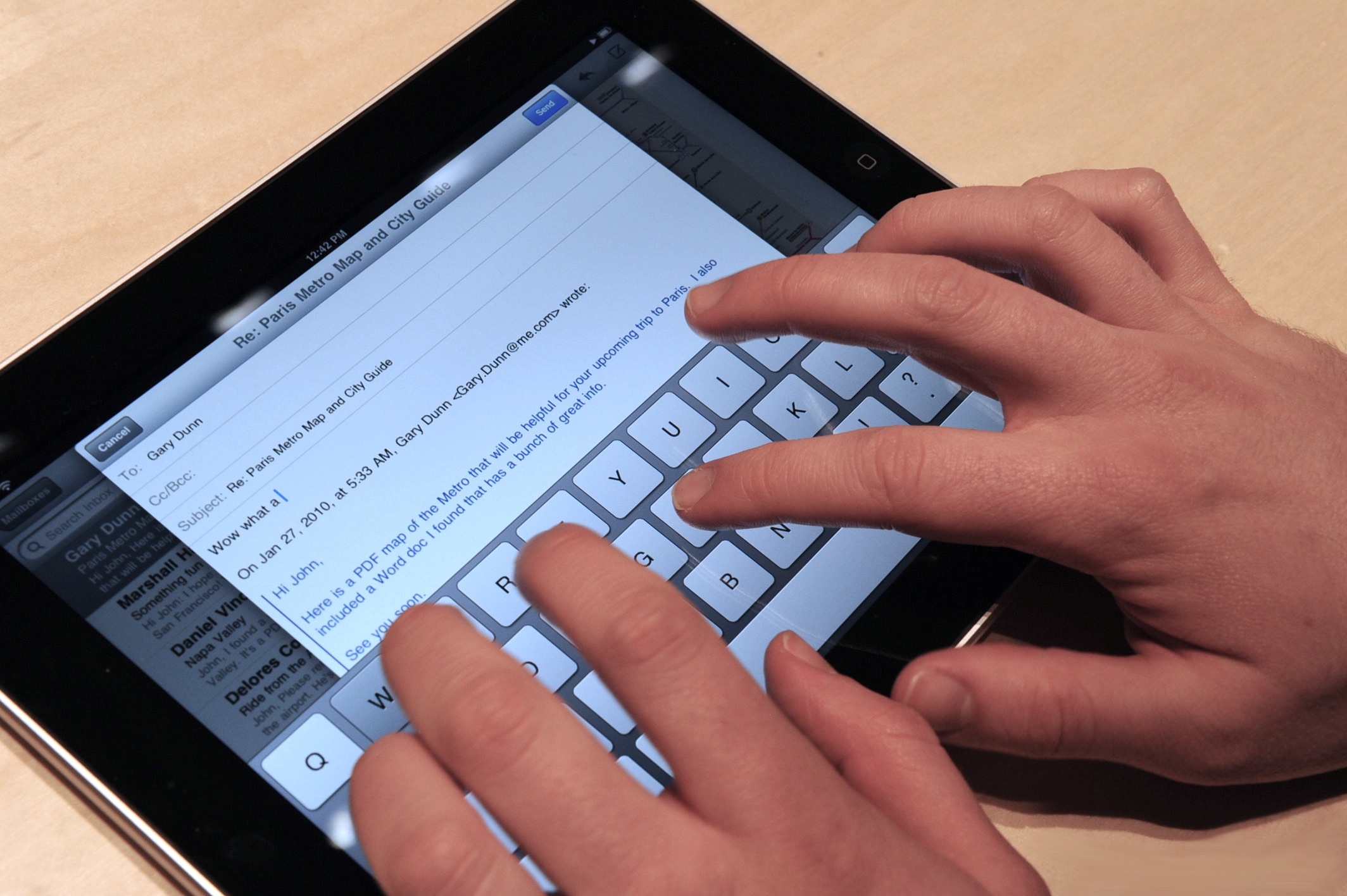 A user typing on an iPad on-screen keyboard