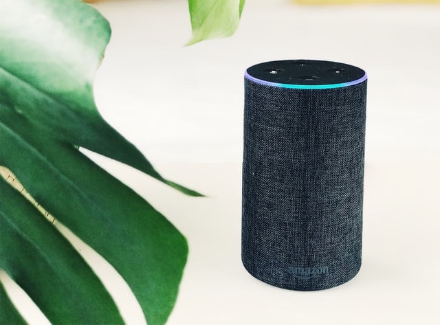 A photograph of an Alexa smart speaker on a table.