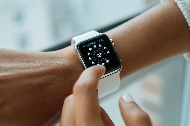A photograph of a person touching an Apple Watch screen