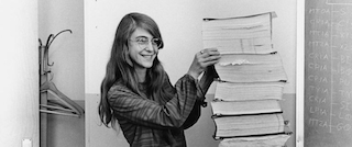 A photograph of Margaret Hamilton standing next to source code.
