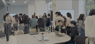 A photograph of a group of students working on laptops