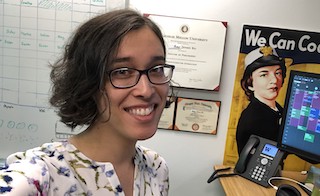 A photograph of Amy smiling at her desk.