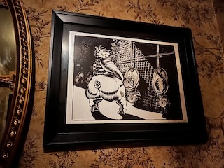 An illustrated black and white pig in prison clothing peeing into a urinal.