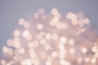 A blurry collection of unfocused pink lights amidst a background of bluish grey.