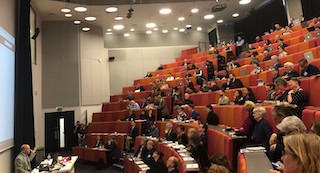 A photograph of a talk during the 2018 iConference showing attendees in stadium seating.