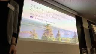 A photograph of me presenting at Koli in front of my slide.