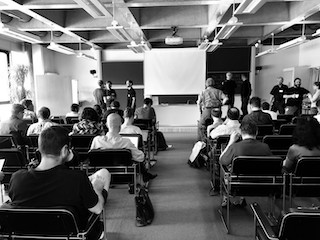A black and white photograph of attendees at the Dagstuhl having conversations.