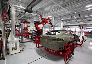 A photograph of a manufacturing robot making a car.