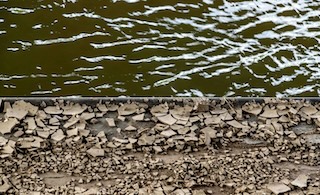 On the top half, green flowing river water, and on the bottom, fractured rock.