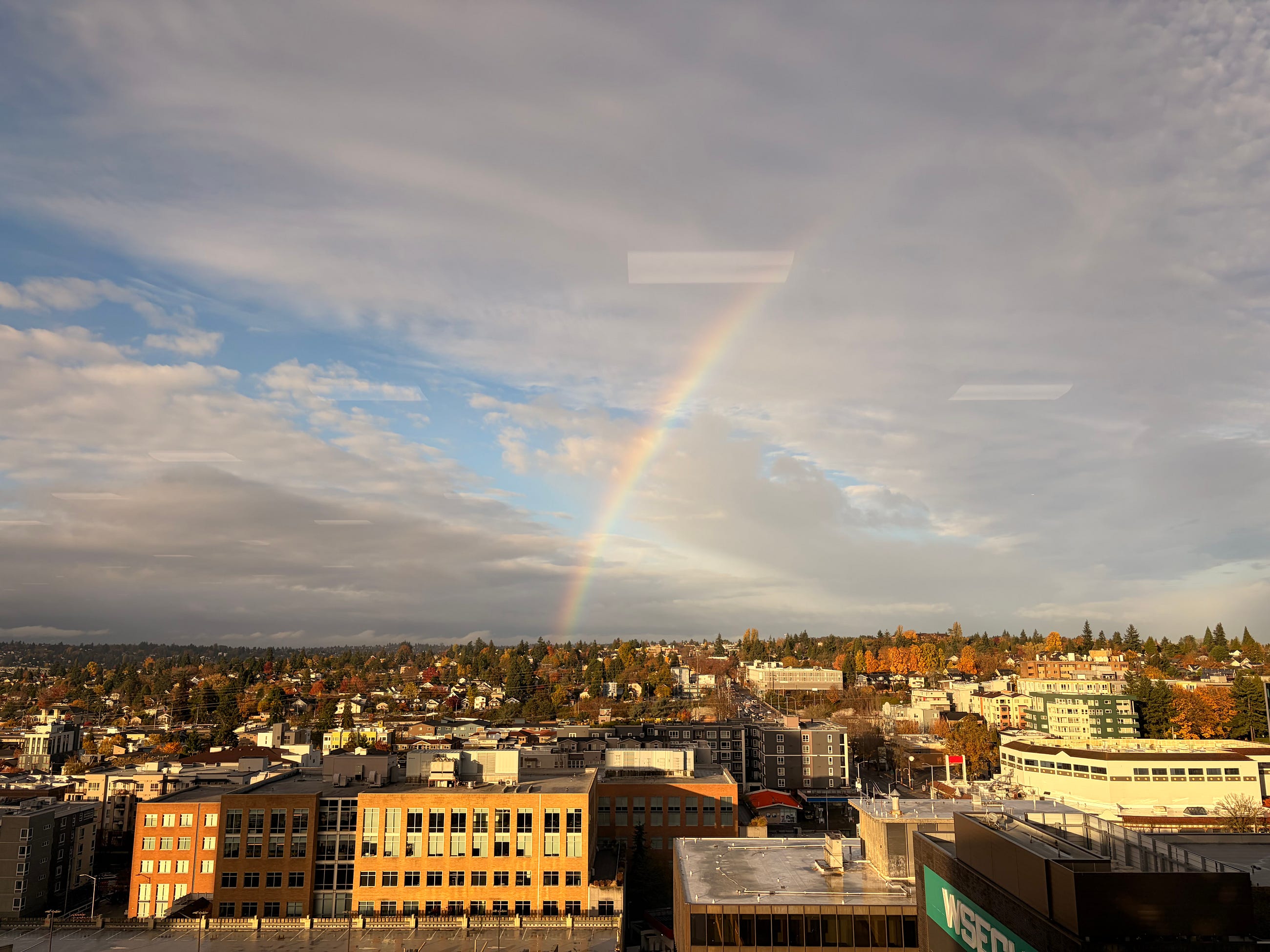 The university district in Seattle, with a post rain shower rainbow amidst a cloudy sky.