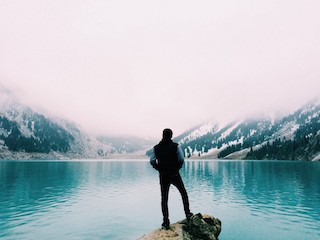 Stock photo of a person staring at a lake.