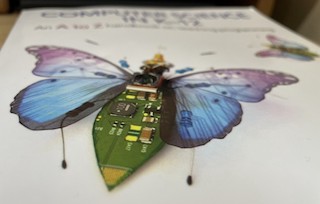 A photograph of the book over showing a robotic butterfly and the book title, blurred in the background.