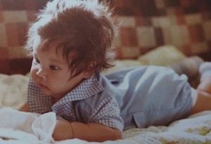 A photograph of Amy when she was an infant, laying on her belly