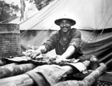 "... American Army Engineer task force in Liberia find themselves in a land from which their ancestors came. Wash day and Pvt. Jack David scrubs out his things on top of a table made from native trees." Ca. July 1942. Fred Morgan. 111-SC-150980-B .  National Archives and Records Administration